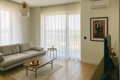 a living room with a couch and a table at Belgrade Waterfront Kalemegdan and River View with Garage in Belgrade