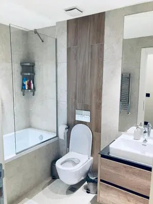 a bathroom with a toilet and a tub and a sink at Belgrade Waterfront Kalemegdan and River View with Garage in Belgrade