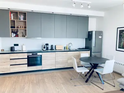 a kitchen with a table and chairs and a refrigerator at Belgrade Waterfront Kalemegdan and River View with Garage in Belgrade