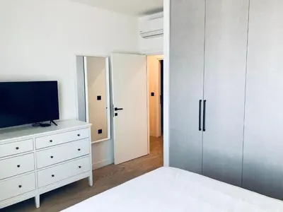 a bedroom with a tv and a white dresser at Belgrade Waterfront Kalemegdan and River View with Garage in Belgrade