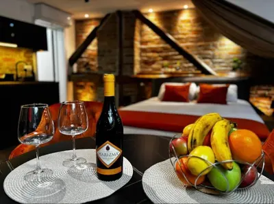 a table with a bottle of wine and a bowl of fruit at Sweet home in Belgrade