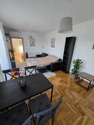 a living room with a bed and a table and chairs at Apartman Emi in Belgrade