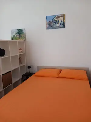 a bedroom with an orange bed and a shelf at Lola in Belgrade