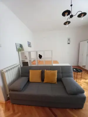 a couch in a living room with yellow pillows at Lola in Belgrade