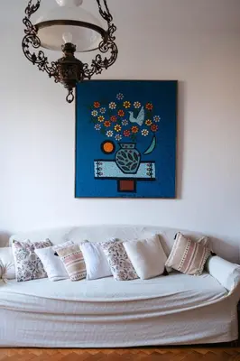 a white couch with pillows in a room with a painting at Sweet House Retro in Belgrade