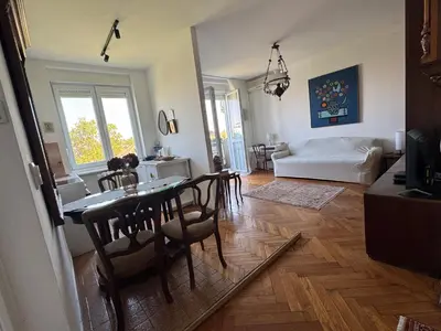a living room with a table and chairs and a living room at Sweet House Retro in Belgrade