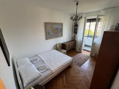 a bedroom with a bed and a chair in it at Sweet House Retro in Belgrade