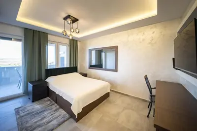 a bedroom with a bed and a desk and a television at Anja D Apartments in Belgrade