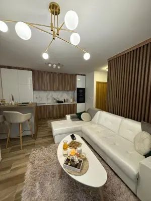 a living room with a white couch and a table at Freedom APARTMAN RUMA in Ruma