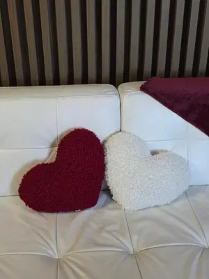 two heart cushions sitting on a white couch at Freedom APARTMAN RUMA in Ruma