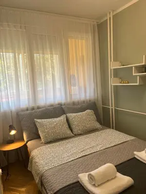 a bedroom with a bed with pillows and a window at Orientale in Belgrade