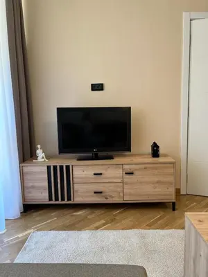 a flat screen tv sitting on top of a wooden entertainment center at Orientale in Belgrade