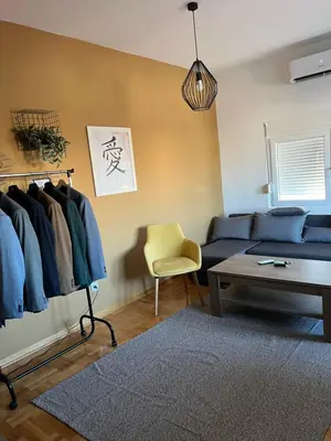 a living room with a blue couch and a table at Mikos apartmani in Belgrade