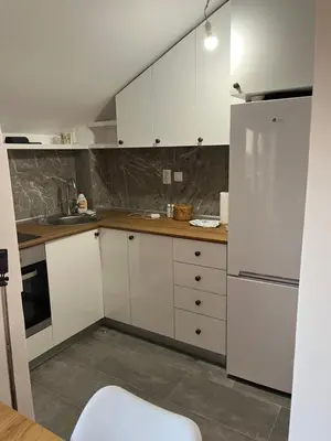 a kitchen with white cabinets and a white refrigerator at Mikos apartmani in Belgrade