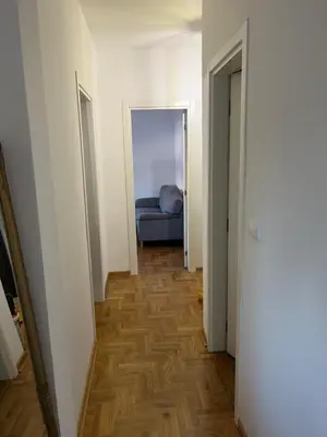 a hallway with a blue bed in a white room at Mikos apartmani in Belgrade
