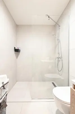 a white bathroom with a shower and a toilet at Belgrade Waterfront LINA Apartments in Belgrade