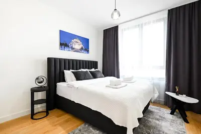 a bedroom with a black and white bed and a window at Belgrade Waterfront LINA Apartments in Belgrade