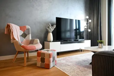 a living room with a television and a chair at Belgrade Waterfront LINA Apartments in Belgrade