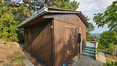 a small wooden building with a staircase in a yard at Beška Sauna View in Beška