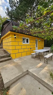 a yellow building with a picnic table in front of it at Beška Sauna View in Beška
