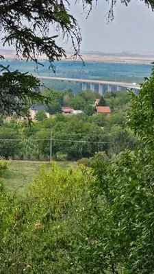 a field with trees and a bridge in the distance at Beška Sauna View in Beška