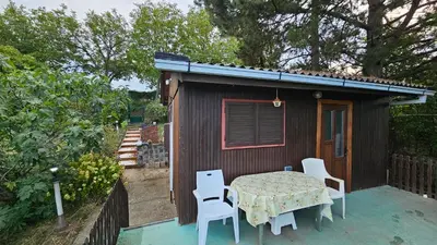 a table and chairs outside of a small house at Beška Sauna View in Beška