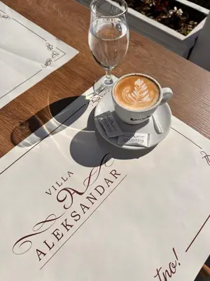 a cup of coffee sitting on top of a table at Vila Aleksandar in Orašac