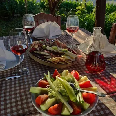 a table with two plates of food and glasses of wine at Vila Aleksandar in Orašac
