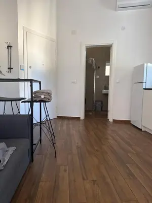 an empty living room with a table and a refrigerator at Amar1 in Belgrade