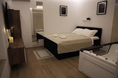 a small bedroom with a bed and a mirror at Point Apartman in Belgrade