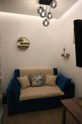 a couch sitting in a living room next to a wall at Point Apartman in Belgrade