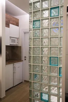 a wall of glass blockades in a kitchen at Point Apartman in Belgrade