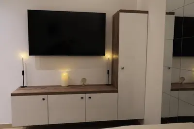 a living room with a tv on a wall at Point Apartman in Belgrade