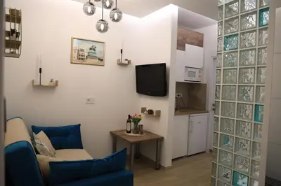 a living room with a blue couch and a tv at Point Apartman in Belgrade