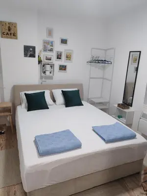 a bedroom with a large white bed with two blue pillows at Studio Kalemegdan in Belgrade