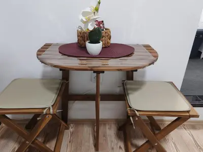 a wooden table with two chairs and a table with a plant at Studio Kalemegdan in Belgrade