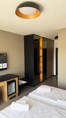 a bedroom with a white bed and a tv at Apartmani Tanasijević