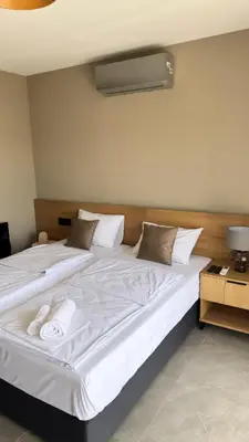 a large white bed with two white towels on it at Apartmani Tanasijević