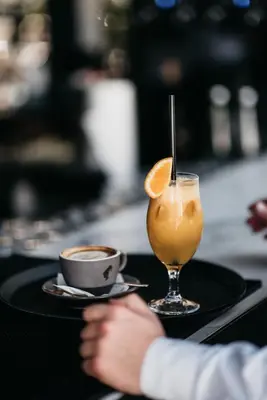 a drink and a cup of coffee on a table at Hotel Heritage in Belgrade