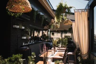 an outdoor restaurant with tables and chairs and plants at Hotel Heritage in Belgrade
