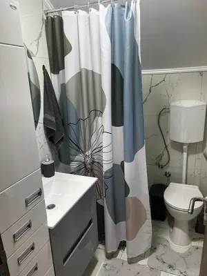 a bathroom with a shower curtain and a toilet at Vila Terasa in Čortanovci
