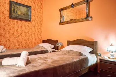 two beds in a room with orange walls at Etno kuća Biblioteka in Smederevo