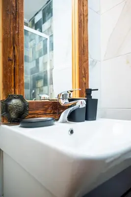 a bathroom with a sink with a mirror and a window at Etno kuća Biblioteka in Smederevo