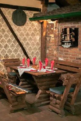 a wooden table with red napkins and glasses on it at Etno kuća Biblioteka in Smederevo