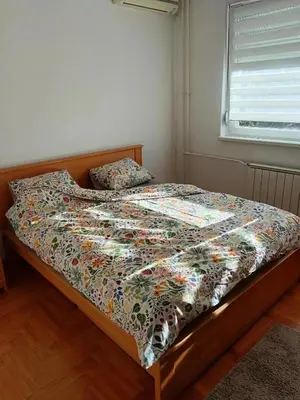 a bed with a colorful comforter in a bedroom at Linda Apartments- Arena in Novi Beograd