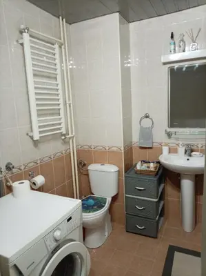 a bathroom with a toilet and a sink and a washing machine at Linda Apartments- Arena in Novi Beograd