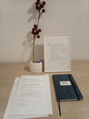 a table with a book and a vase with a plant at Linda Apartments- Arena in Novi Beograd