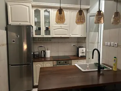 a kitchen with white cabinets and a stainless steel refrigerator at Apartment 48 in Belgrade