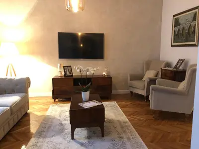 a living room with a couch and a tv at Vračar Elegance Apartment in Belgrade