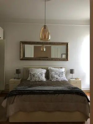 a bedroom with a bed with two pillows and a mirror at Vračar Elegance Apartment in Belgrade